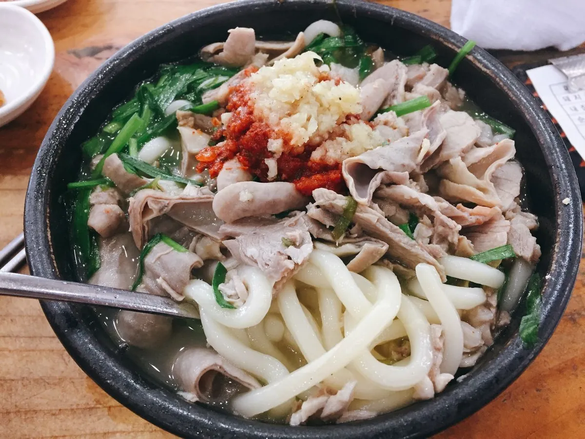 一碗豬肉湯飯加入了大量的配料，包括豆腐、辣椒和粉絲，展現出不同於一般豬肉湯飯的口味變化。