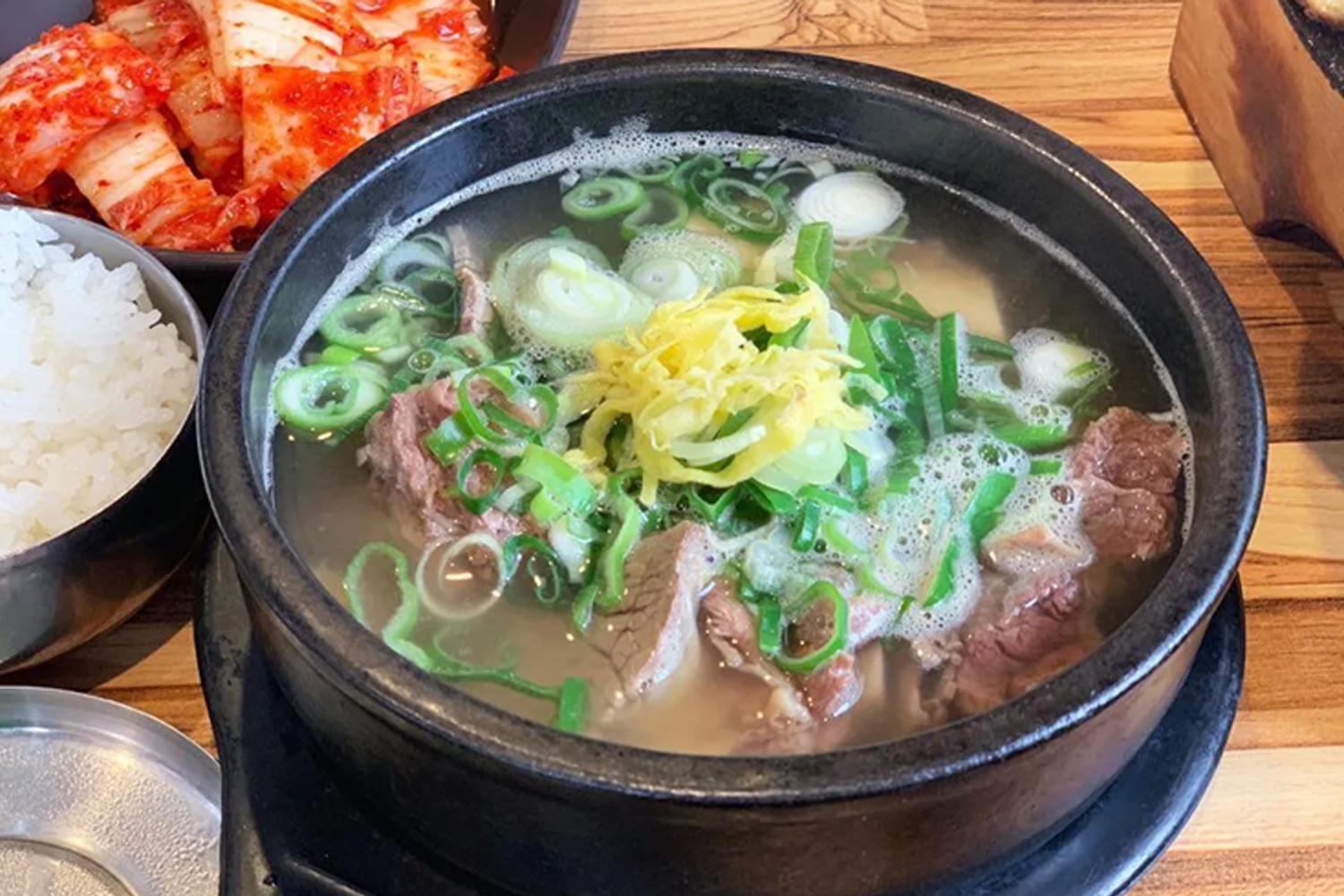 一碗韓式牛骨湯的圖片，牛肉和大葱混合的清澈湯頭。