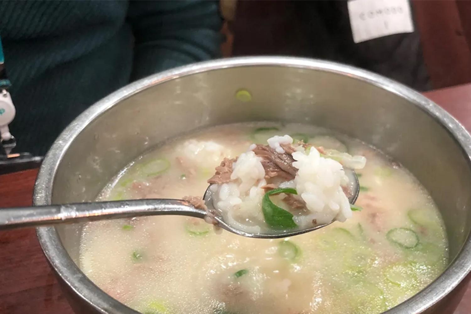 韓式飯桌上的一碗牛肉湯，旁邊配有韓式小菜的圖片。