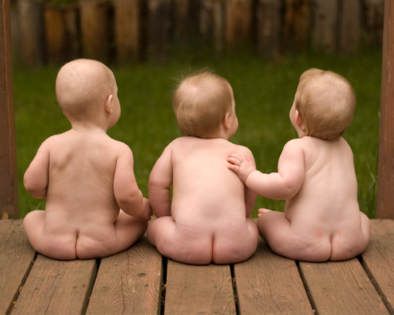 三個光著身子的嬰兒從後方觀看，象徵夢中出現三胞胎帶來的好運。