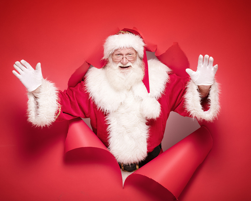 一名著名人物以聖誕老人裝扮站在紅色背景前，象徵接待名人的夢境。