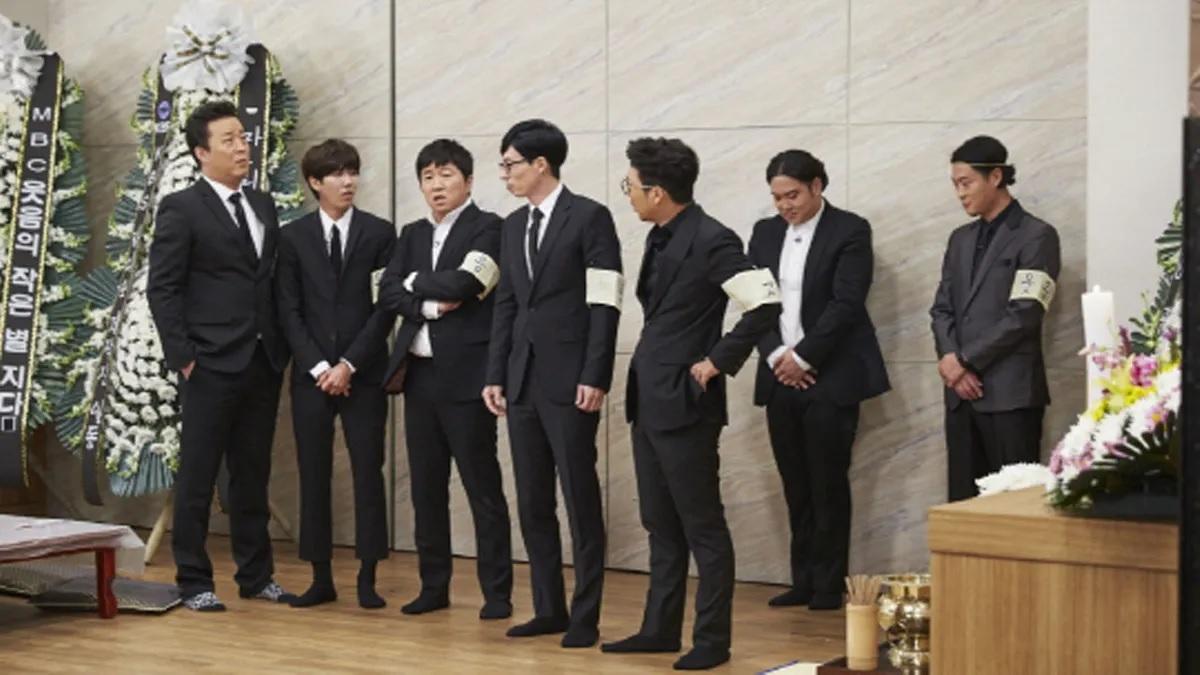 ภาพพิธีงานศพแบบเกาหลีที่ผู้คนสวมชุดสูทสีดำและมีพวงหรีดอยู่ด้านหลัง, แสดงถึงธรรมเนียมงานศพของเกาหลี