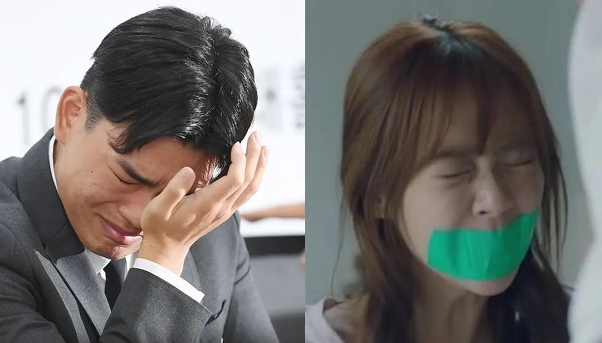 ชายในชุดสูทสีดำกำลังใช้มือขวาจับศีรษะ ตัวเขาหันหน้าไปทางซ้ายมือ พื้นหลังเบลอบางส่วนแต่มีความเป็นทางการ ประกอบด้วยสีขาวและสีดำ