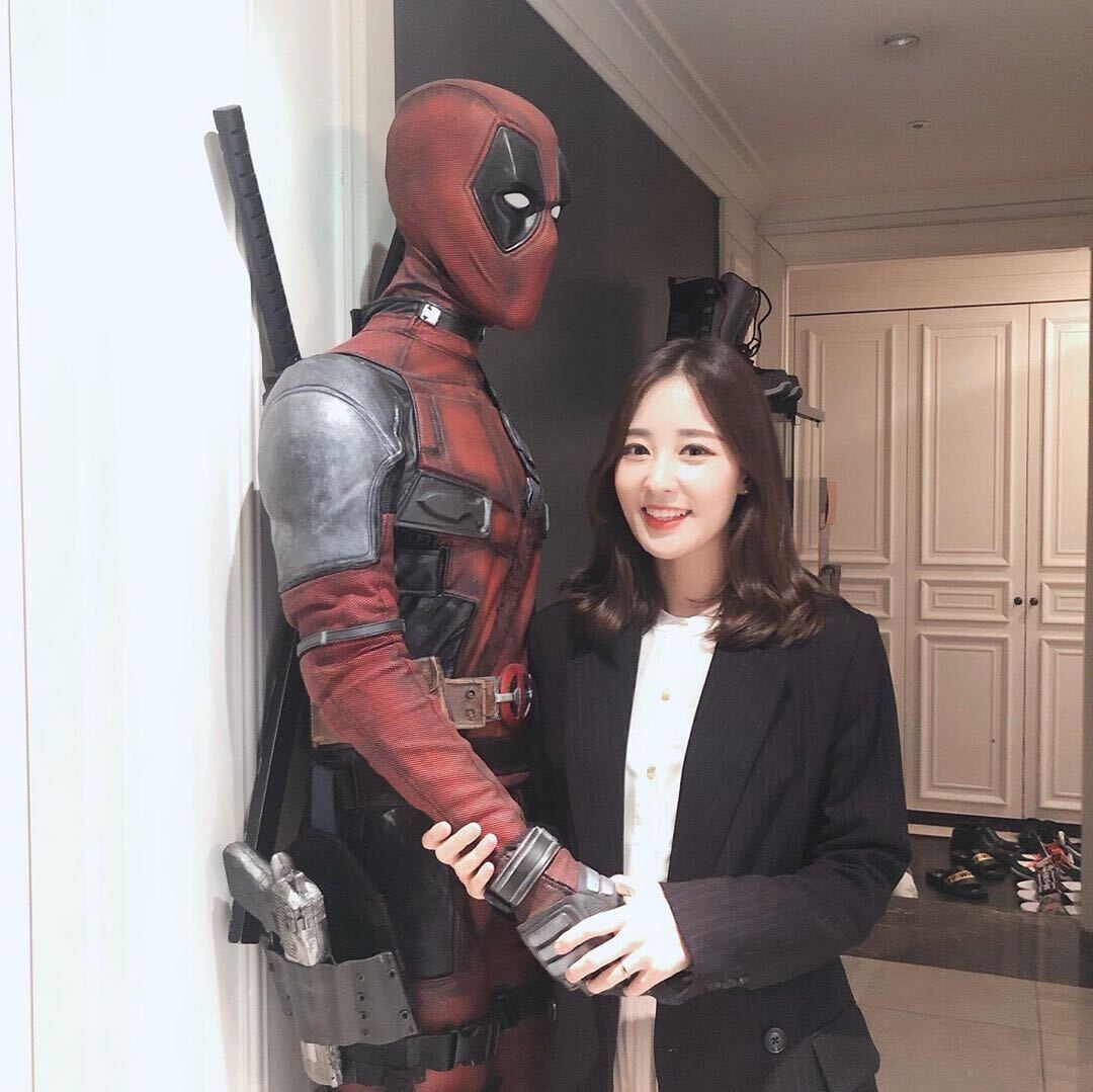 หญิงสาวจับมือรูปปั้น Deadpool ในบริเวณบ้านที่มีการตกแต่งคล้ายกับบ้านของไอดอล