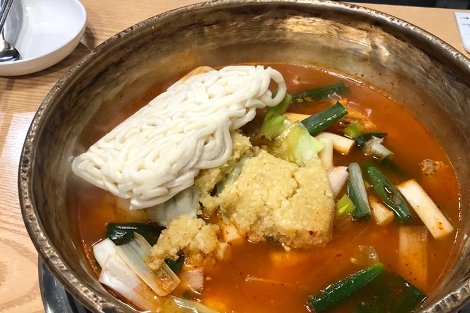 韓式燉雞，放滿香辣濃鬱的剁辣椒、青葱、泡菜等食材，熱氣撲鼻。