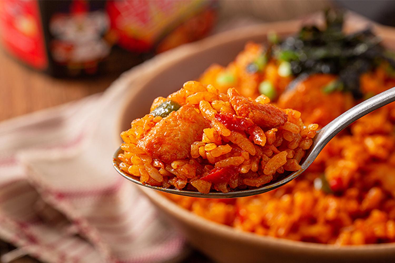 辣雞炒飯，紅辣辣的炒飯，有豐富的辣雞撈麵醬與芝麻點綴，帶來獨特風味。
