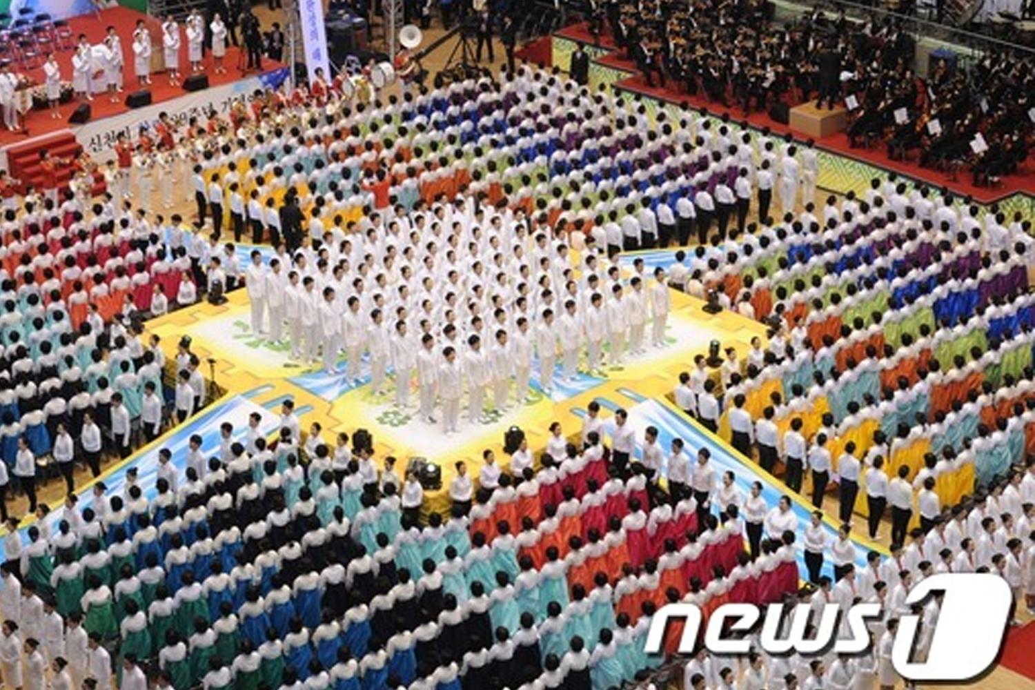 聚集在韓國體育場的羣眾穿着色彩鮮豔的衣服，進行大型活動。