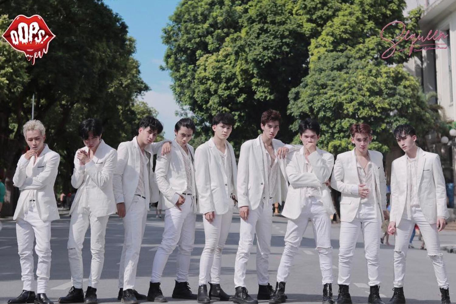 Nhóm nhảy nam Oops Crew trong trang phục trắng biểu diễn ngoài trời với cây xanh xung quanh.