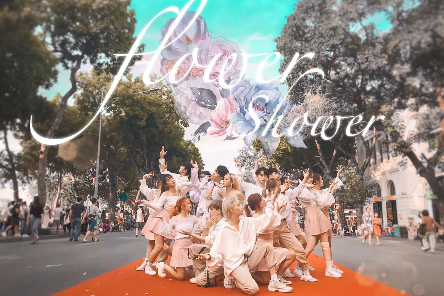 Nhóm nhảy C.A.C trong trang phục trắng, sắp xếp đội hình trên đường phố với chữ 'Flower Shower' phía trên.