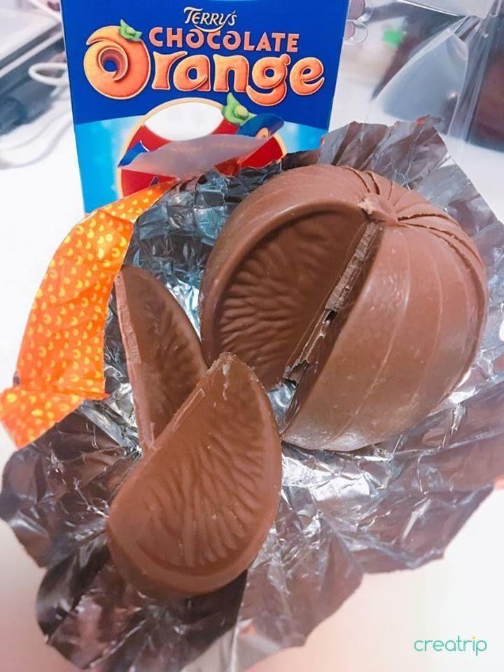 A fully opened Terry's Chocolate Orange with chocolate orange segments laid out showing the detailed textured surface.