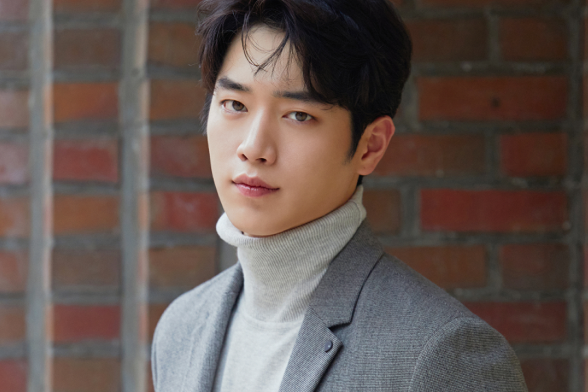 徐康俊以灰色套裝出鏡，背景為磚牆，完美結合都市與自然的氣息，增添他卓越的紳士風範。