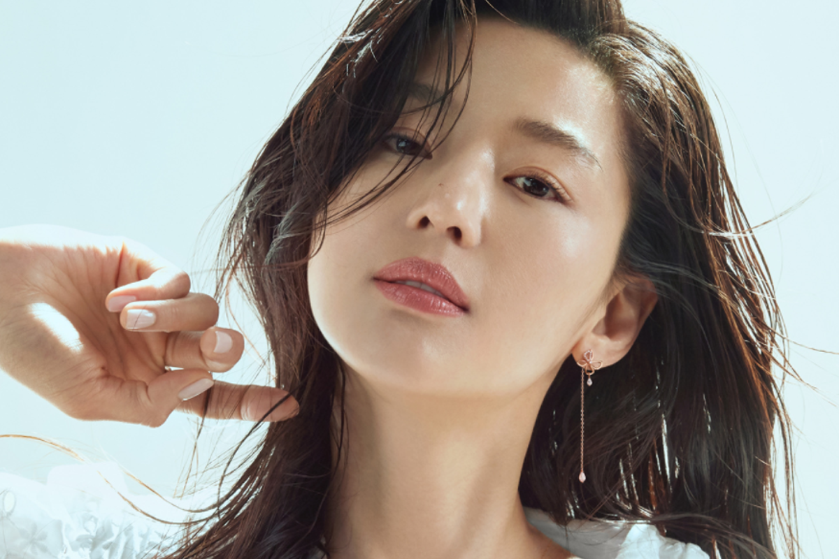 全智賢身着華麗耳環，黑色捲髮自然垂落，展現出一種自然優雅的魅力。背景為明亮的白色，襯托出她的高貴姿態。