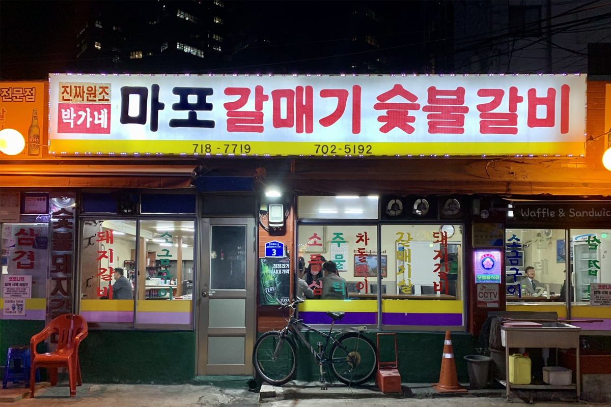 孔德市場中夜晚繁忙的美食街，攤位間的招牌與燈光交織