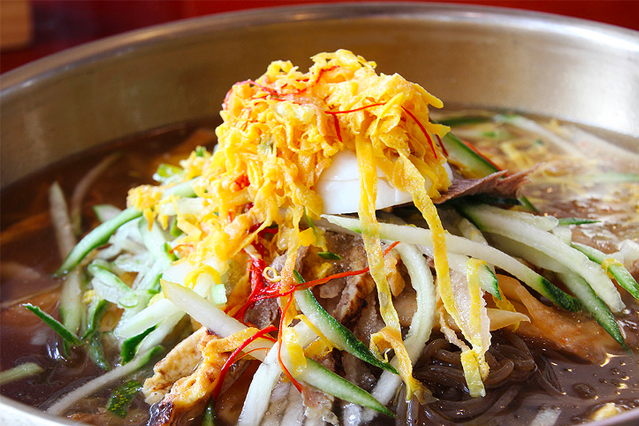 碗裡的平壤冷麵，用牛肉湯、蕎麥麵和幾種調味料精心調製，完美展現北韓地區的飲食文化。