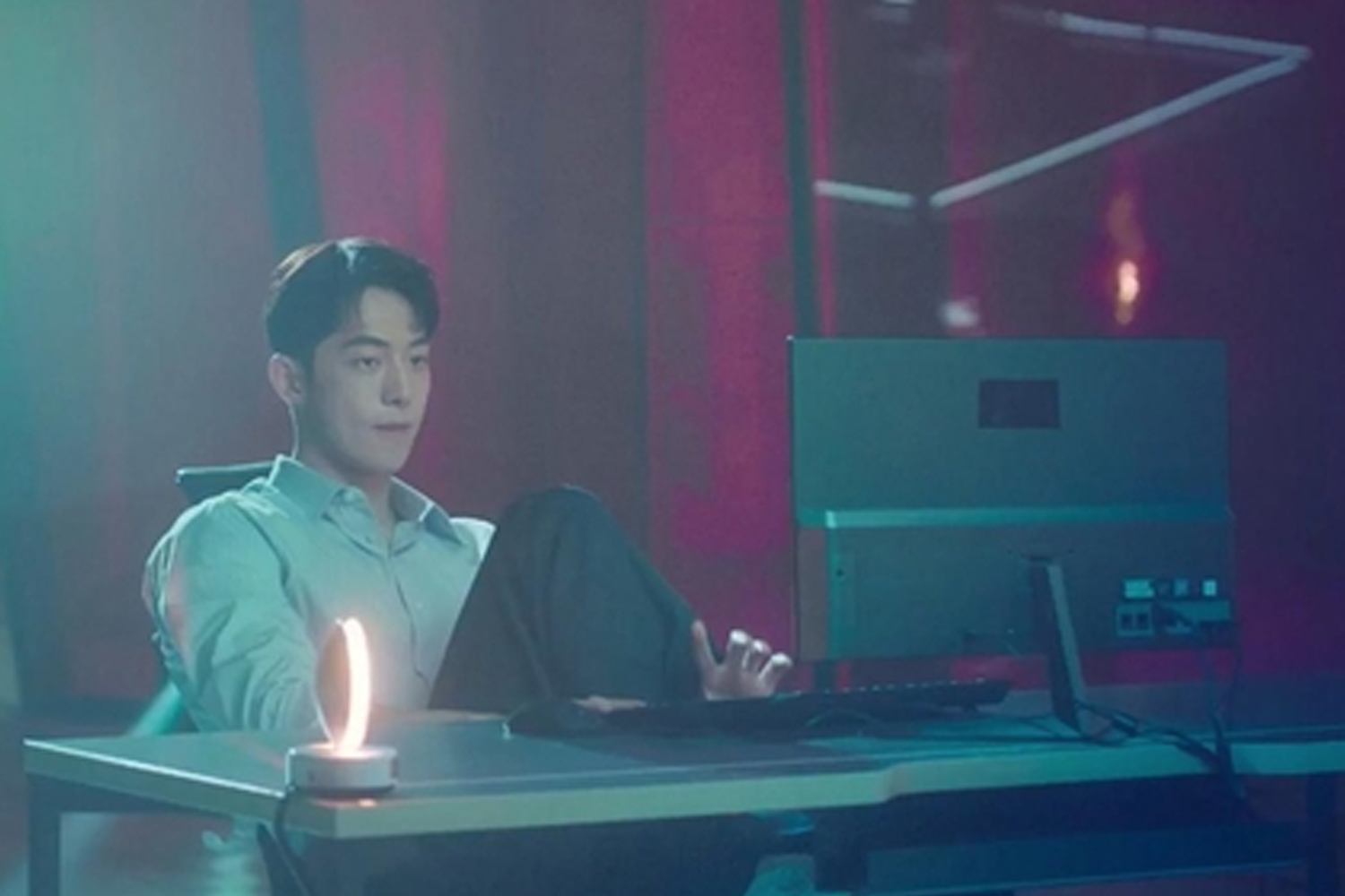 一名男子坐在電腦前,燈光柔和,營造出韓劇《Start Up》中專注思考的工作氛圍。