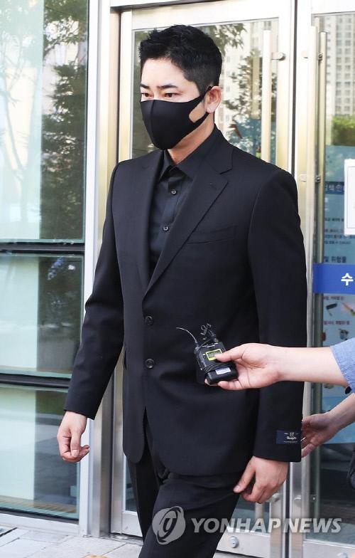 黒いスーツを着た男性がレポーターの前でインタビューを受けている様子、韓国の俳優に関連したニュース記事の一部