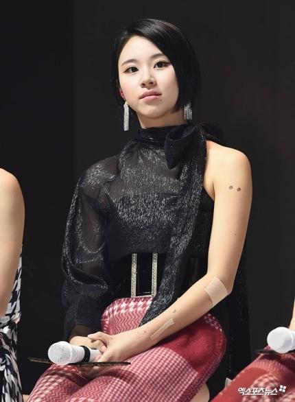 TWICEのメンバーがマイクを持って座っている様子