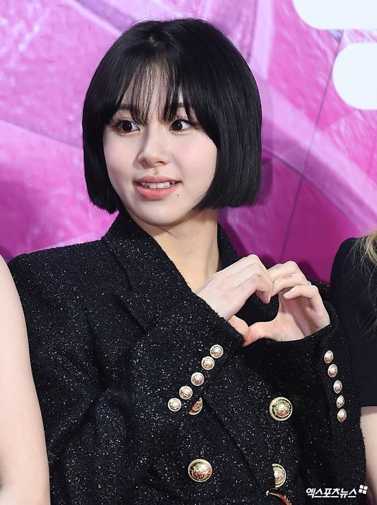 TWICEのメンバーが公式イベントで手でハートを作っている様子