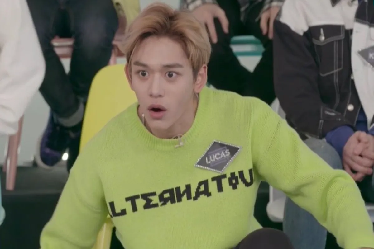 ภาพบุคคลในเสื้อกล้ามสีเขียวตัวหนึ่งที่มีชื่อ 'Lucas' ด้วยตัวอักษรสีดำ และมีข้อความที่เกี่ยวข้องกับความสับสนในวัฒนธรรมเกาหลี.