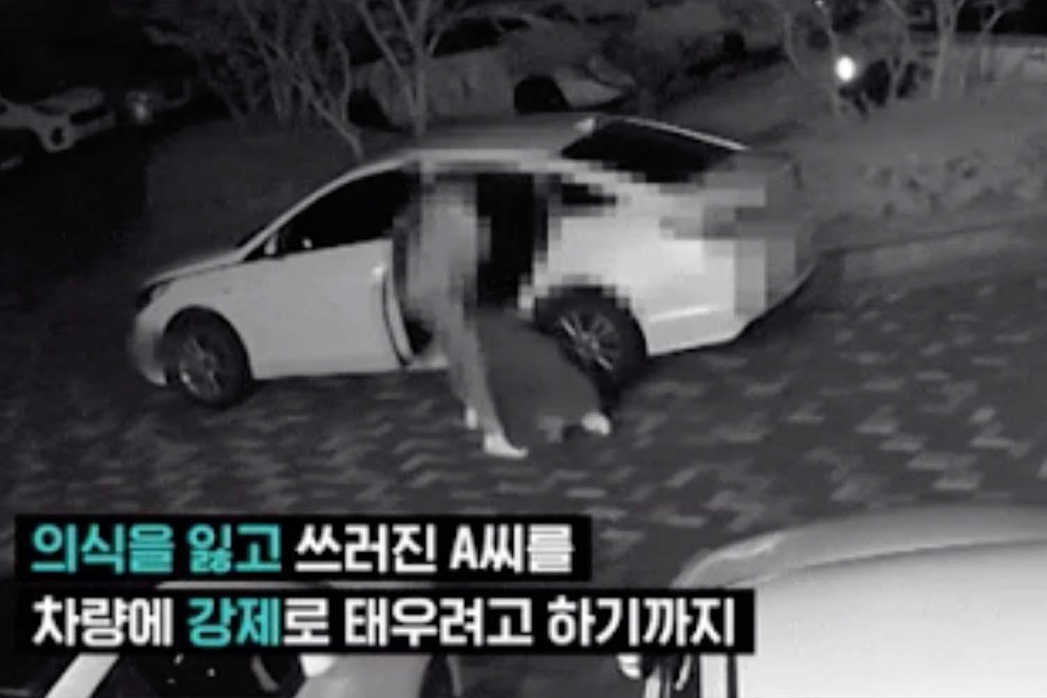 ภาพจากกล้องวงจรปิดในพื้นที่นอกอาคารที่แสดงที่คนสองคนอยู่ใกล้กับรถยนต์สีขาว คนหนึ่งดูเหมือนจะลากอีกคนหนึ่งบนพื้น.มีข้อความเป็นภาษาเกาหลีอยู่ในภาพ.