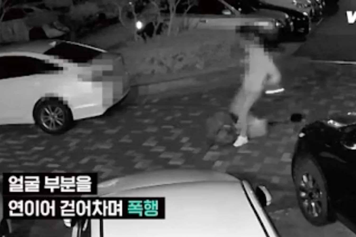 ภาพจากกล้องวงจรปิดของพื้นที่ภายนอกแสดงเหตุการณ์ที่มีคนอยู่ในสภาวะบ้าคลั่งบริเวณถนนคอนกรีตข้างรถยนต์สีขาวและสีดำบางส่วนในพื้นหลัง