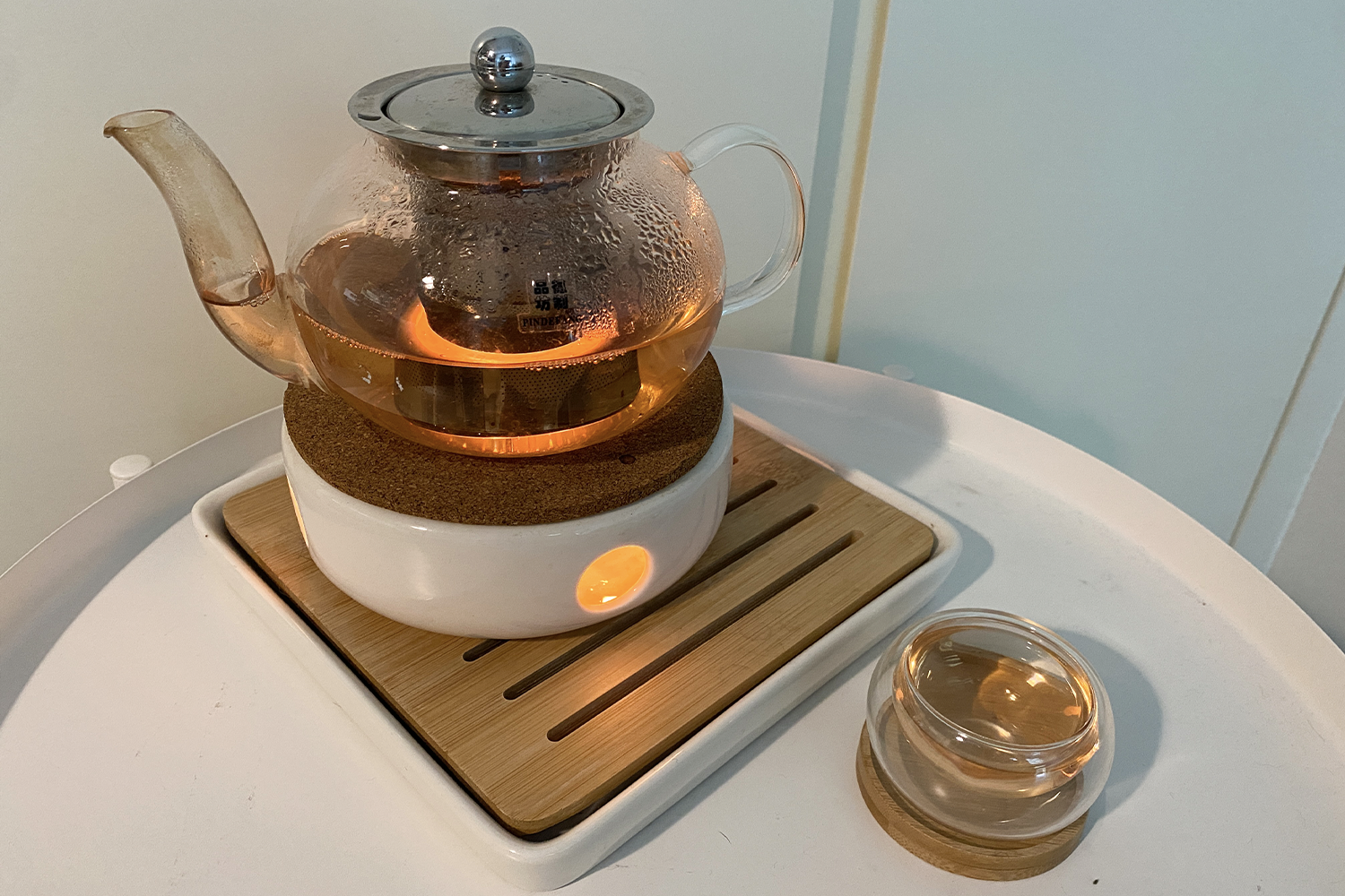 一个洁净的茶壶中泡制的草药茶,放在白色桌面上。