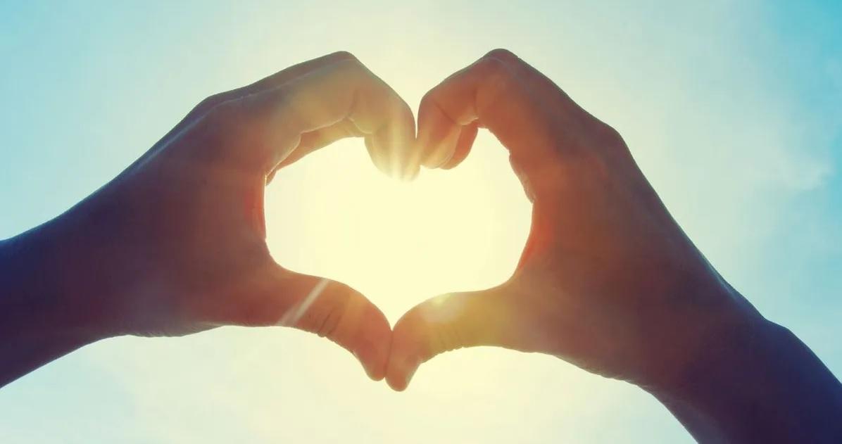 มือที่ทำสัญลักษณ์รูปหัวใจต่อหน้าพระอาทิตย์ สื่อถึงความรักและความหวานแหววในการสารภาพรัก