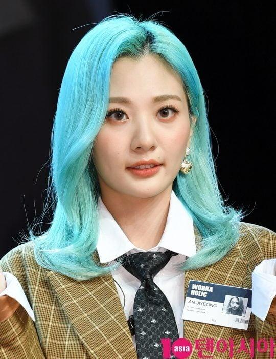 赤頬思春期のアン・ジヨンがマイクを持っている写真。鮮やかな黄色の衣装を着ている。バックグラウンドは黒で、舞台上の様子を示している。