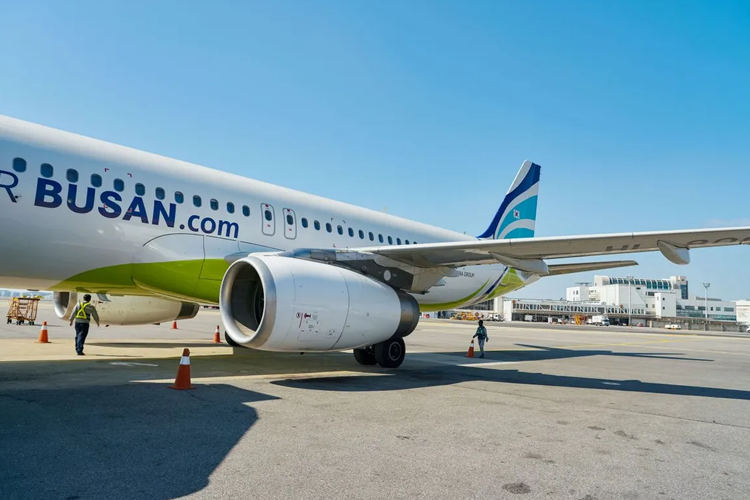 釜山航空的飛機停在跑道上，配備空地維護員。