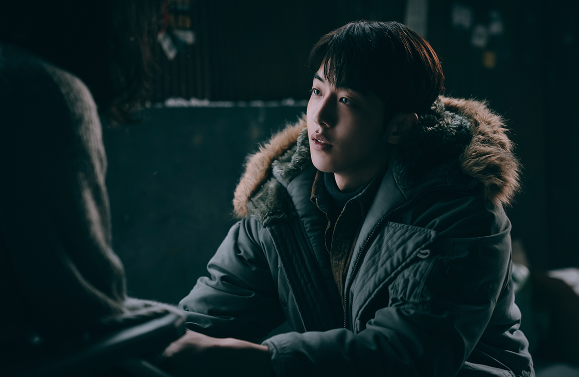 《喬瑟與老虎、魚》中的場景，一位坐在輪椅上的女生在夕陽下，染上一層金黃色的光芒。看起來她在思考某些事情。