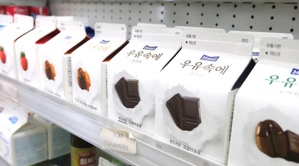 กล่องนมหลากหลายรสชาติเรียงรายอยู่บนชั้นวางในร้านสะดวกซื้อของเกาหลี