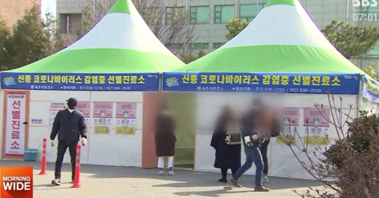 COVID-19 Testing Tent in South Korea, 南韓的 COVID-19 測試帳篷，一個男子走向帶有韓文標語的醫療診斷帳篷。