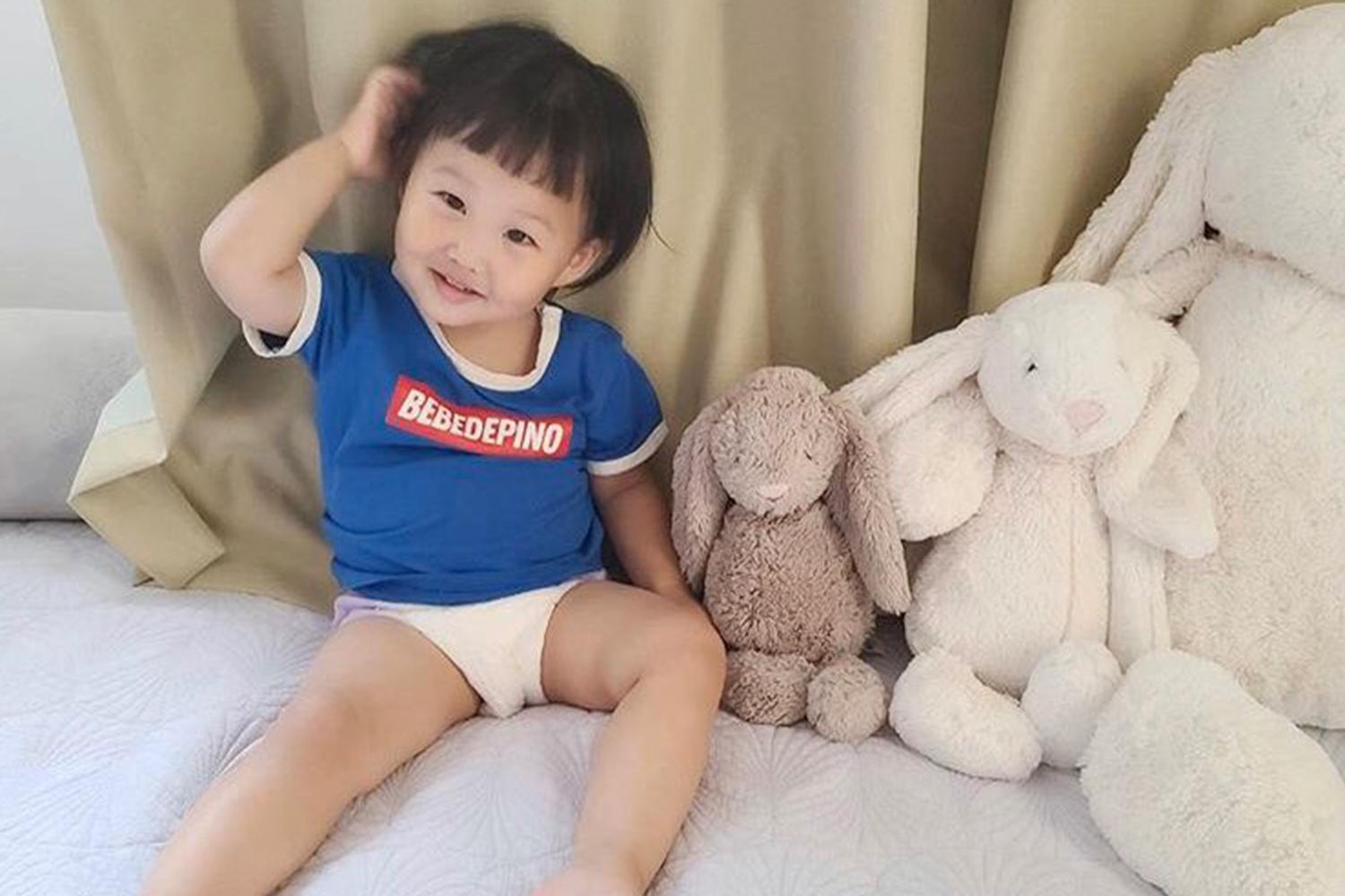 都河穎與毛絨玩具合影，身穿藍色T恤