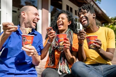 韓国のノグリラーメンを楽しむ3人の外国人。韓国の人気ラーメンが国際的に愛される様子。