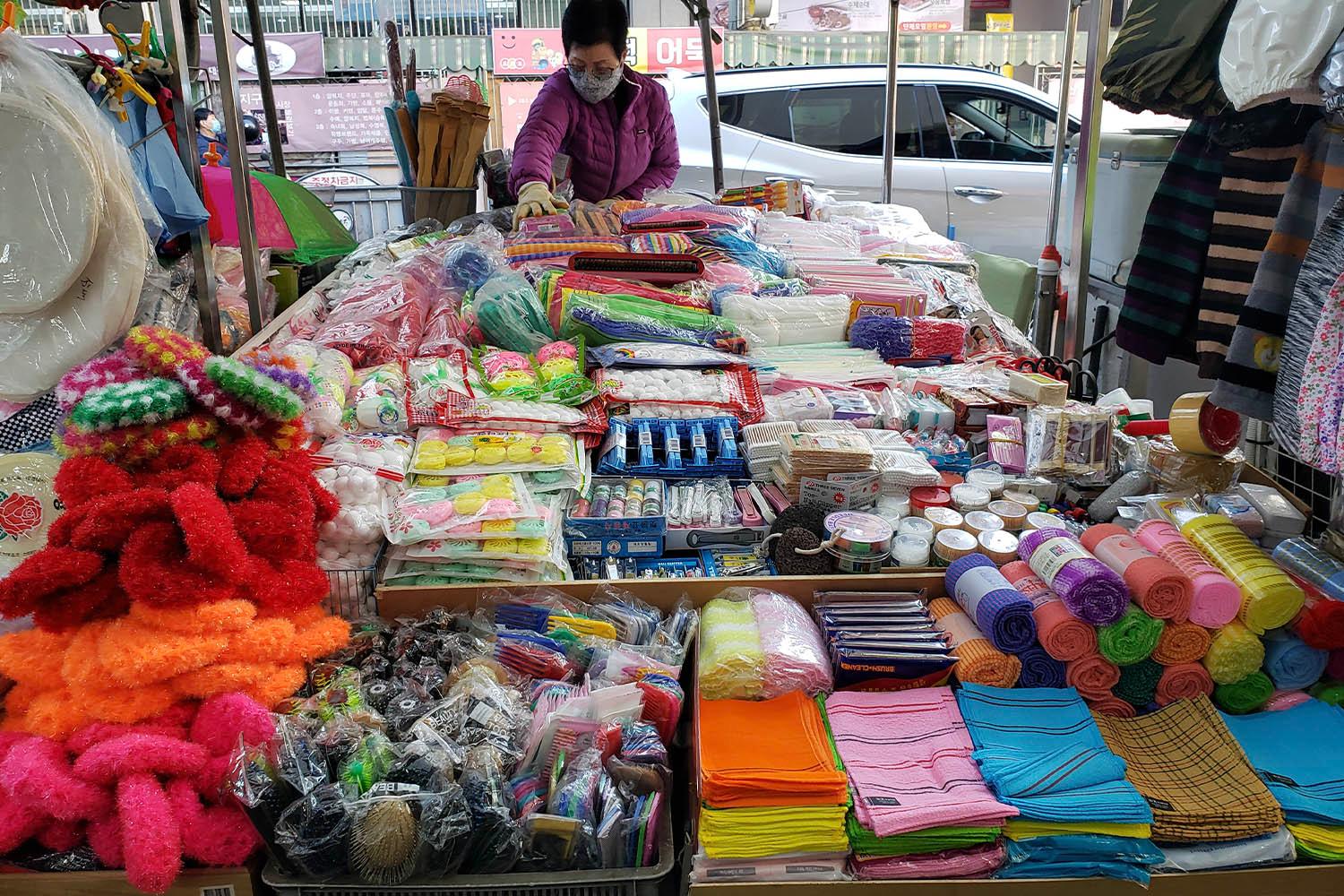 西門市場の屋台で、さまざまなカラフルな商品が並べられているシーン