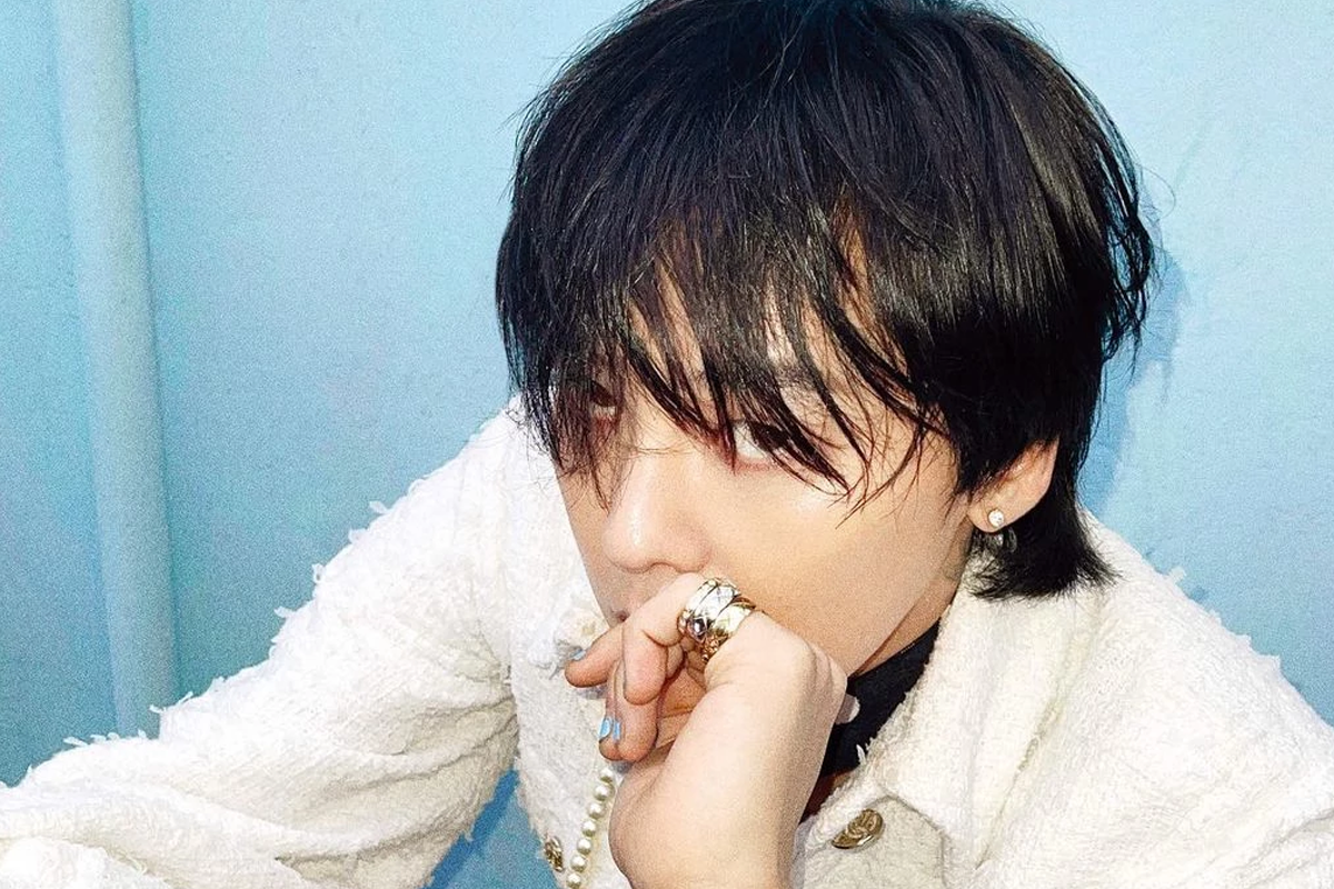 BIGBANG成員G-Dragon於室外背景，身穿典雅外套，佩戴珍珠項鍊。