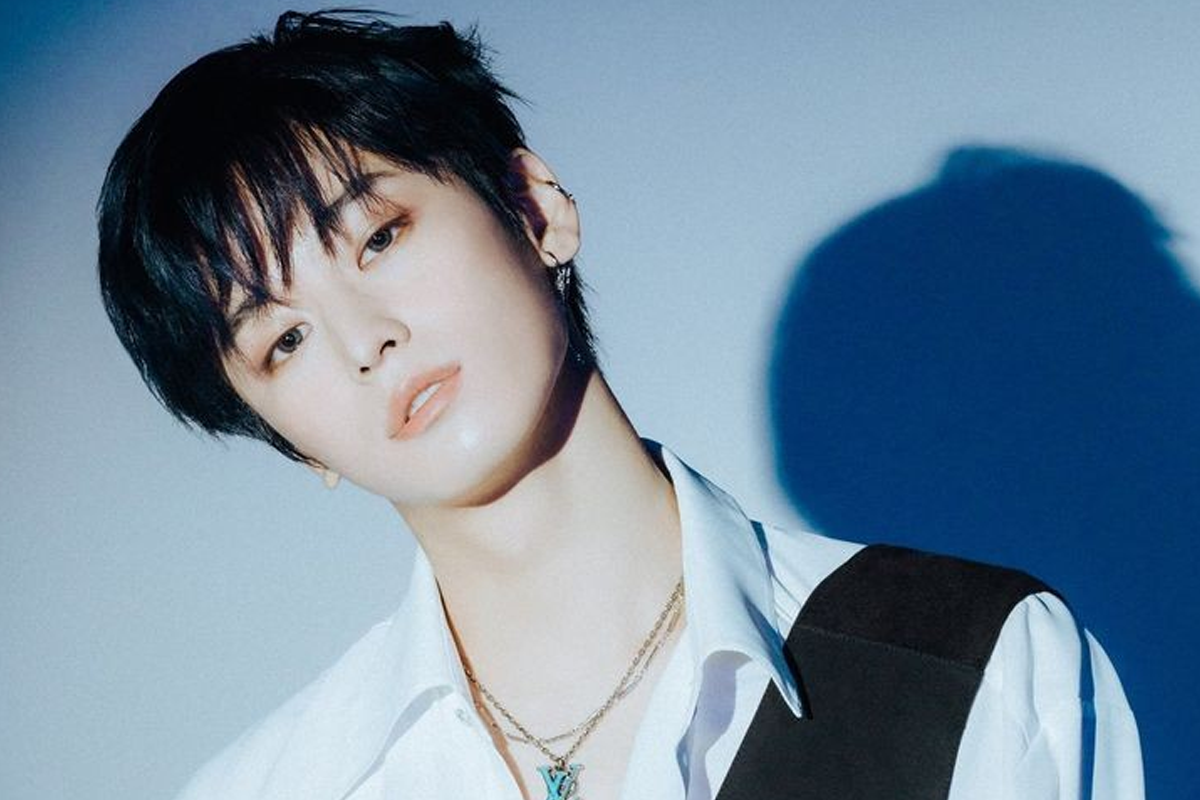 THE BOYZ成員柱延身穿花紋T恤，背景是紅色磚牆。