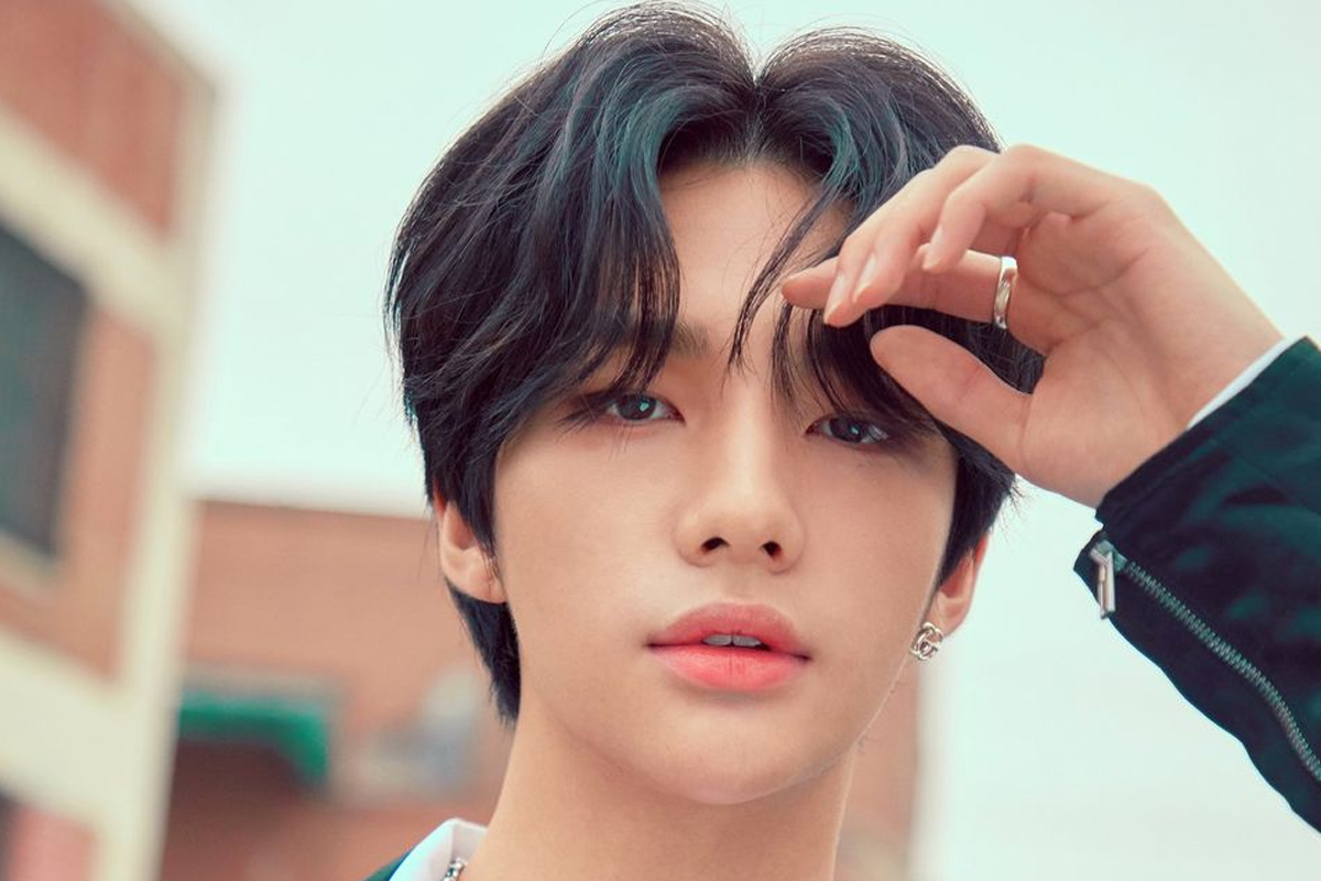 Stray Kids成員鉉辰身穿白色上衣，於背景中伸手握著一根繩子。