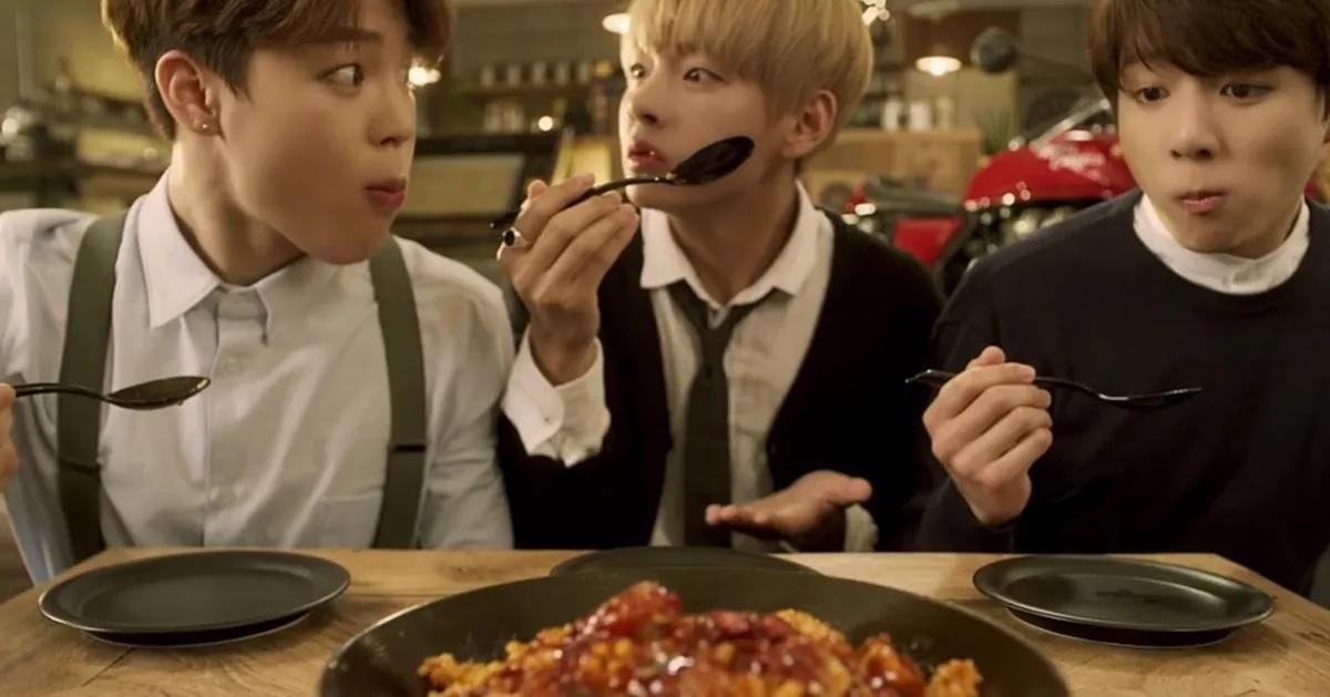 ไก่ทอดราดซอสที่โต๊ะที่จัดไว้พร้อมกับผู้คนถือช้อนเตรียมพร้อมกิน