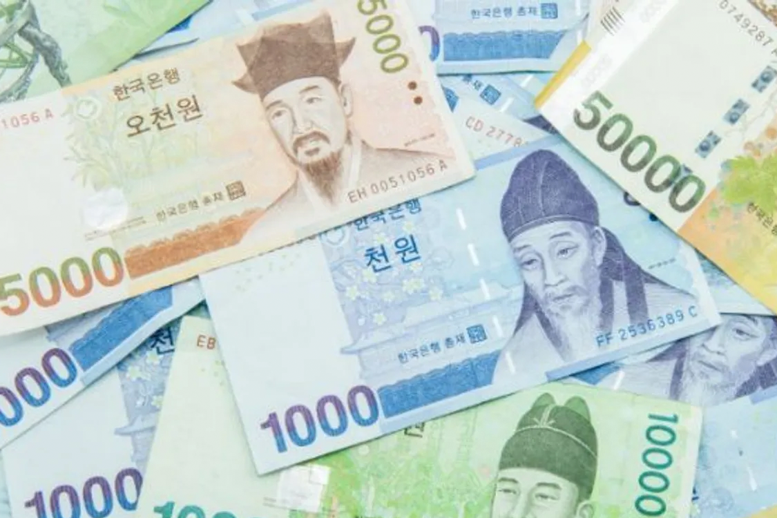 多張韓元鈔票堆疊，顯示出韓國疫情期間人們對於經濟市場動向的關注。