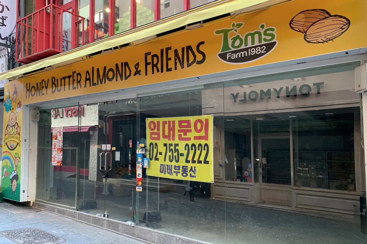 因疫情影響而關閉的韓國餐廳，玻璃窗上貼有出租信息，顯示出市場的困境。