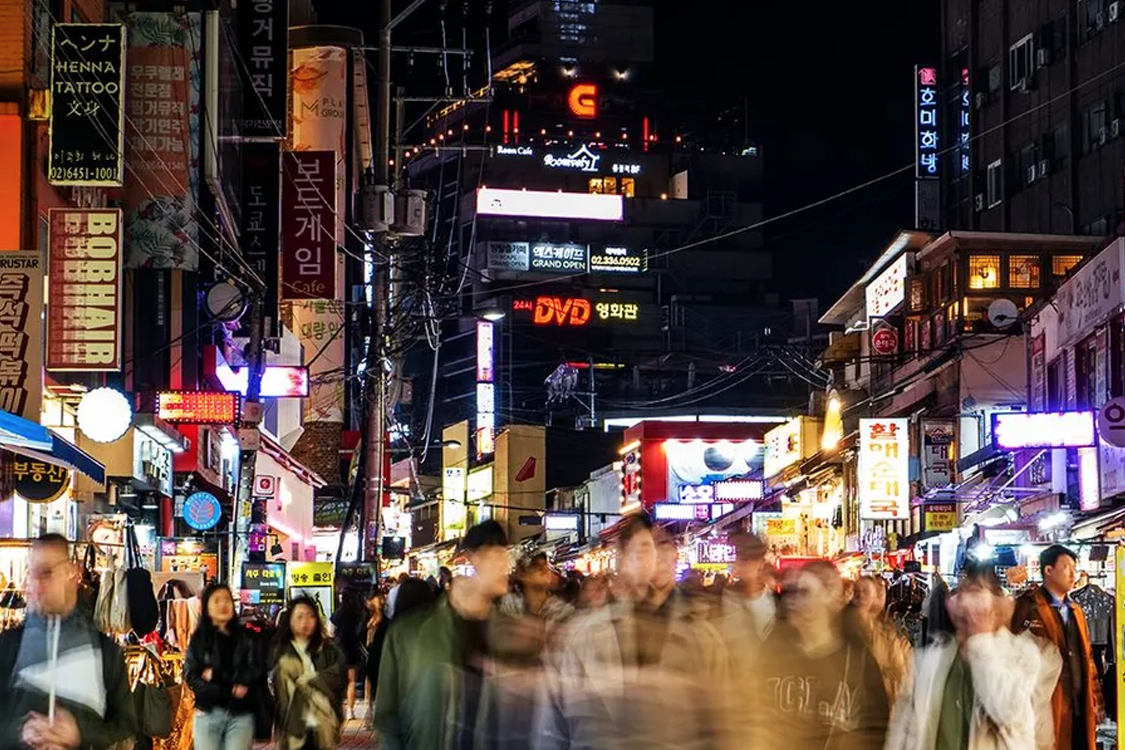 韓國城市夜景，燈火通明，多家商業廣告牌爭奇鬥艷，象徵著經濟的恢復與活力。
