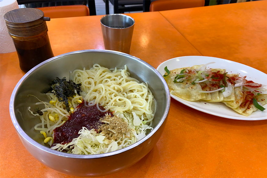 美成堂餐桌上的面和薄饺子的组合，显示了大众推荐的经典大邱美食搭配。