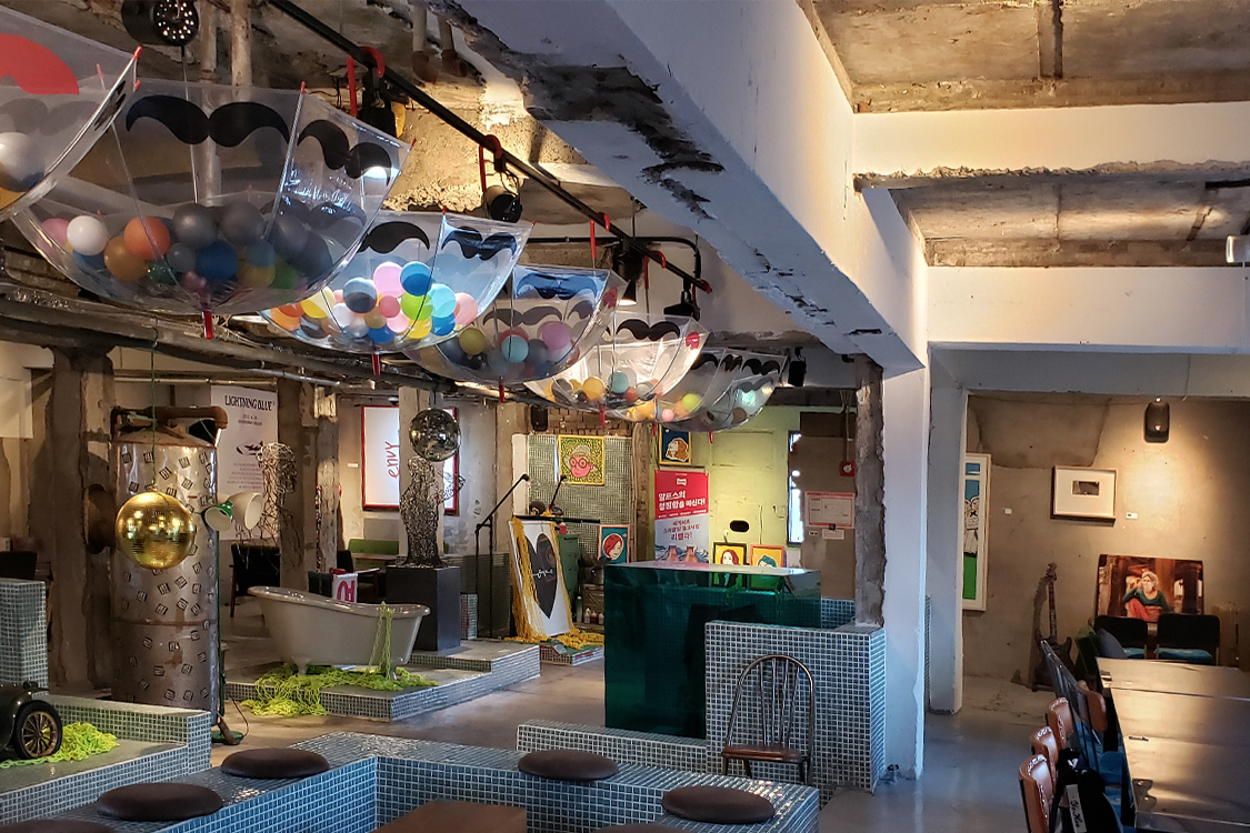 Bereich mit Kunstinstallationen und einem Iron Man Modell im Café Mounhowazhang.