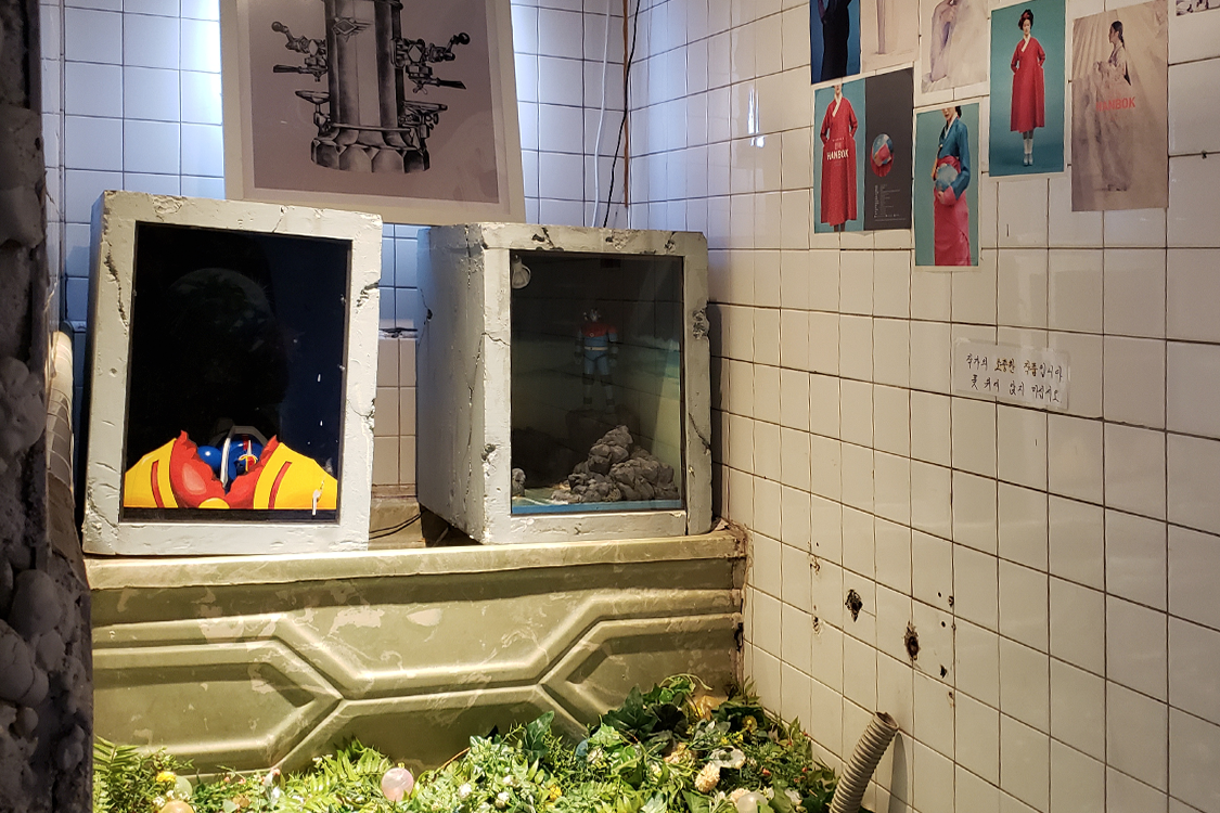 文畫裝咖啡廳的浴室裡展示著工業風格的藝術作品。