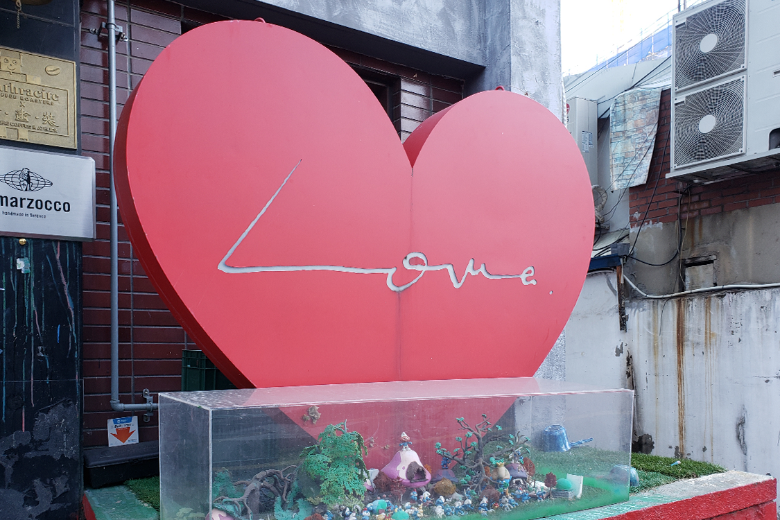 文畫裝咖啡廳門口的心形裝飾特寫，寫著 Love 字樣。