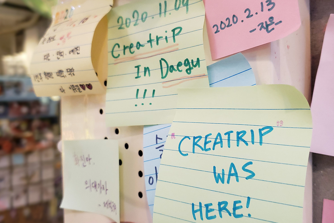 文畫裝咖啡廳裡的留言板，上面寫著多張訪客的信息紙條。