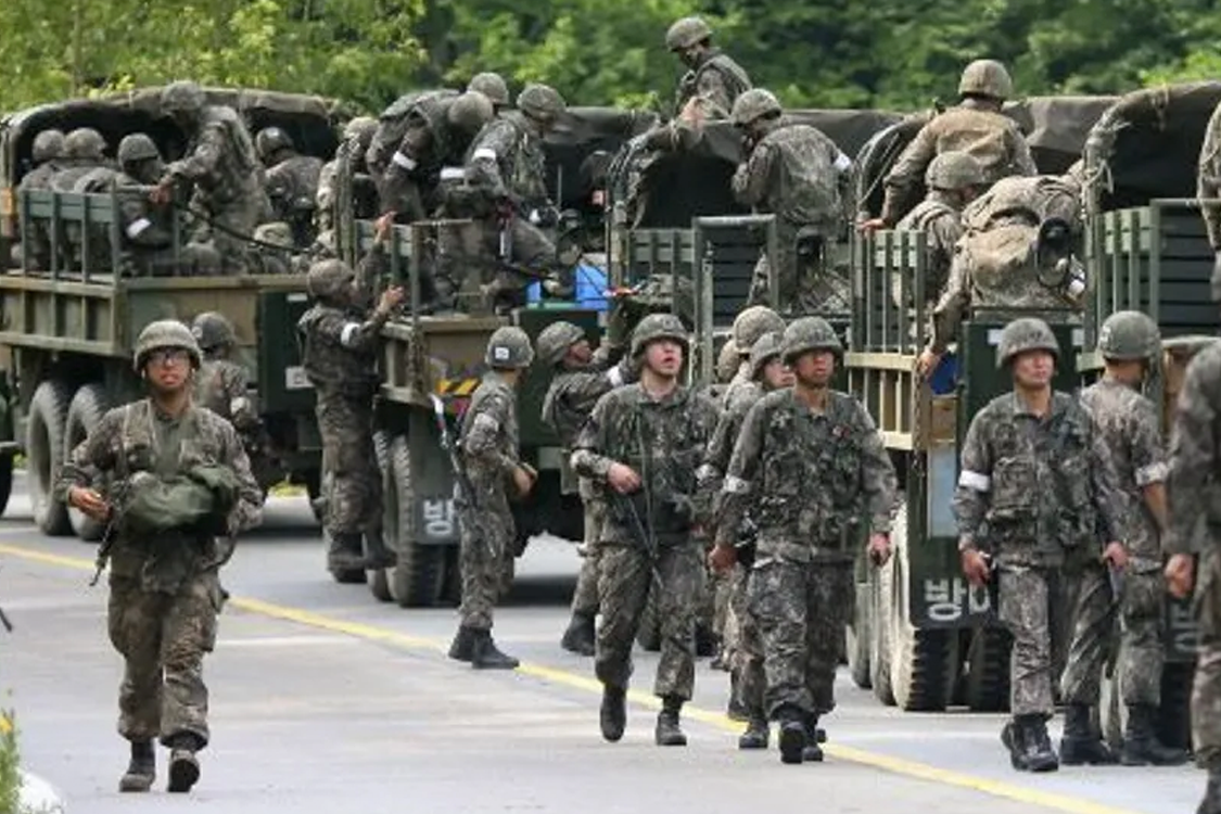 一名人在戶外紅地毯活動中擺出手勢，旨在傳達一種公開出席活動的影像。