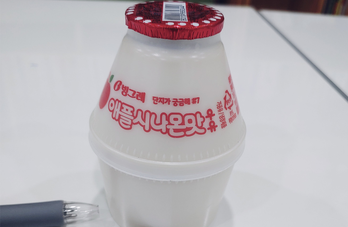 蘋果肉桂牛奶單瓶特寫，在桌面上呈現