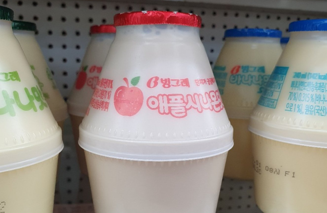 超市陳列的蘋果肉桂牛奶，前景突出顯示瓶身圖案